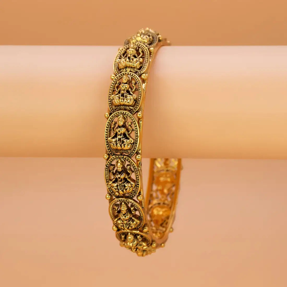 Antique Gold Plated Lakshmi Kada Bangle showcasing intricate carvings of Goddess Lakshmi on a lotus.