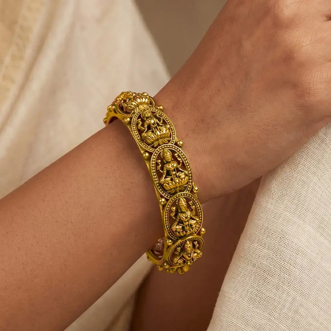 Antique Gold Plated Lakshmi Kada Bangle showcased on a hand, featuring intricate Goddess Lakshmi designs.