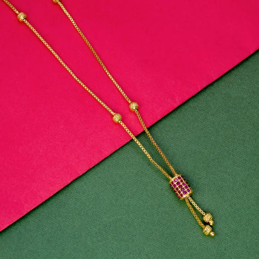 Elegant Gold Plated Cylindrical Stone Pendant Chain with ruby accent on vibrant pink and green background.