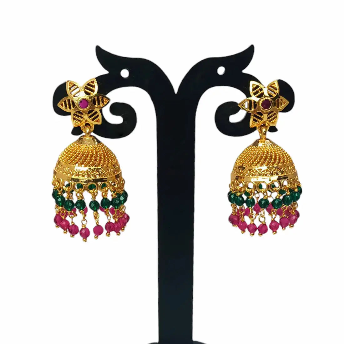 Pair of gold earrings with green and pink beads on a black stand.