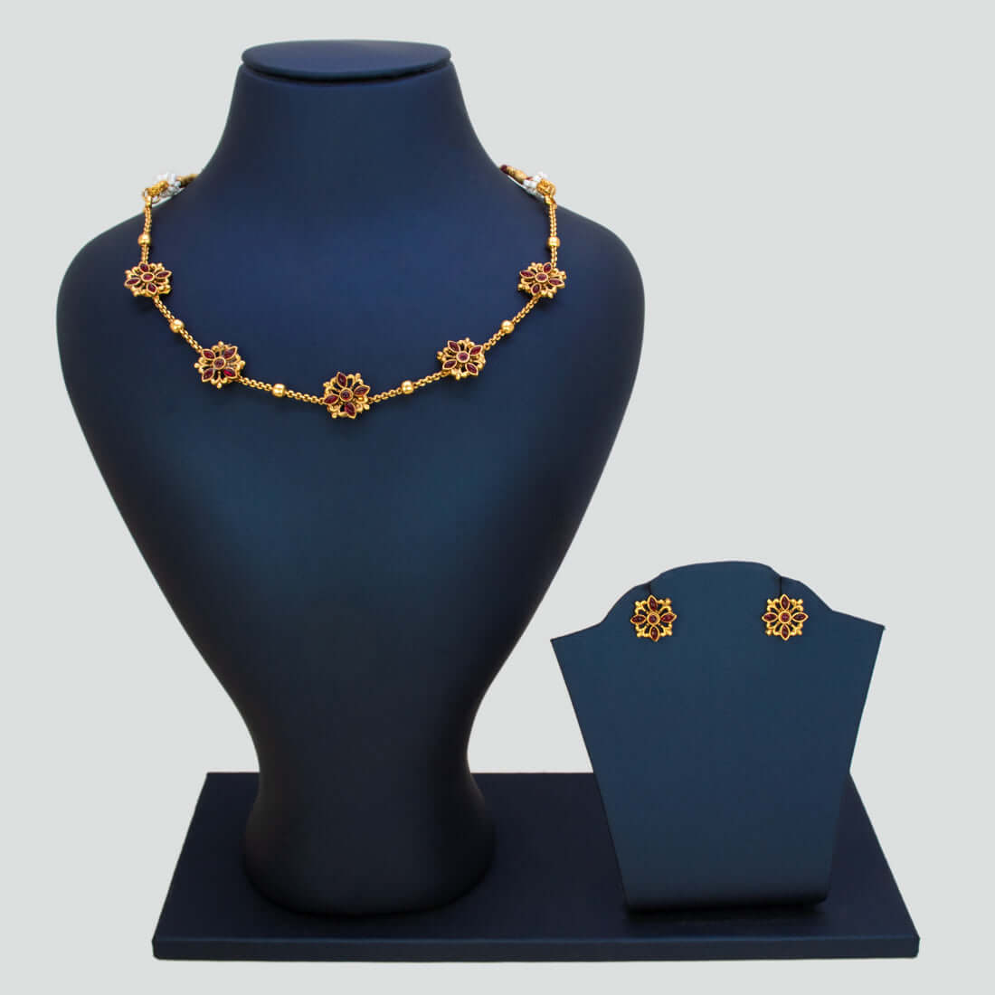 Floral Kemp Stone Antique Gold Choker Necklace Set displayed on a jewelry stand with matching earrings.