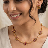 Floral Kemp Stone Antique Gold Choker Necklace Set worn by a woman, featuring ruby-red marquise floral motifs and gold accents.
