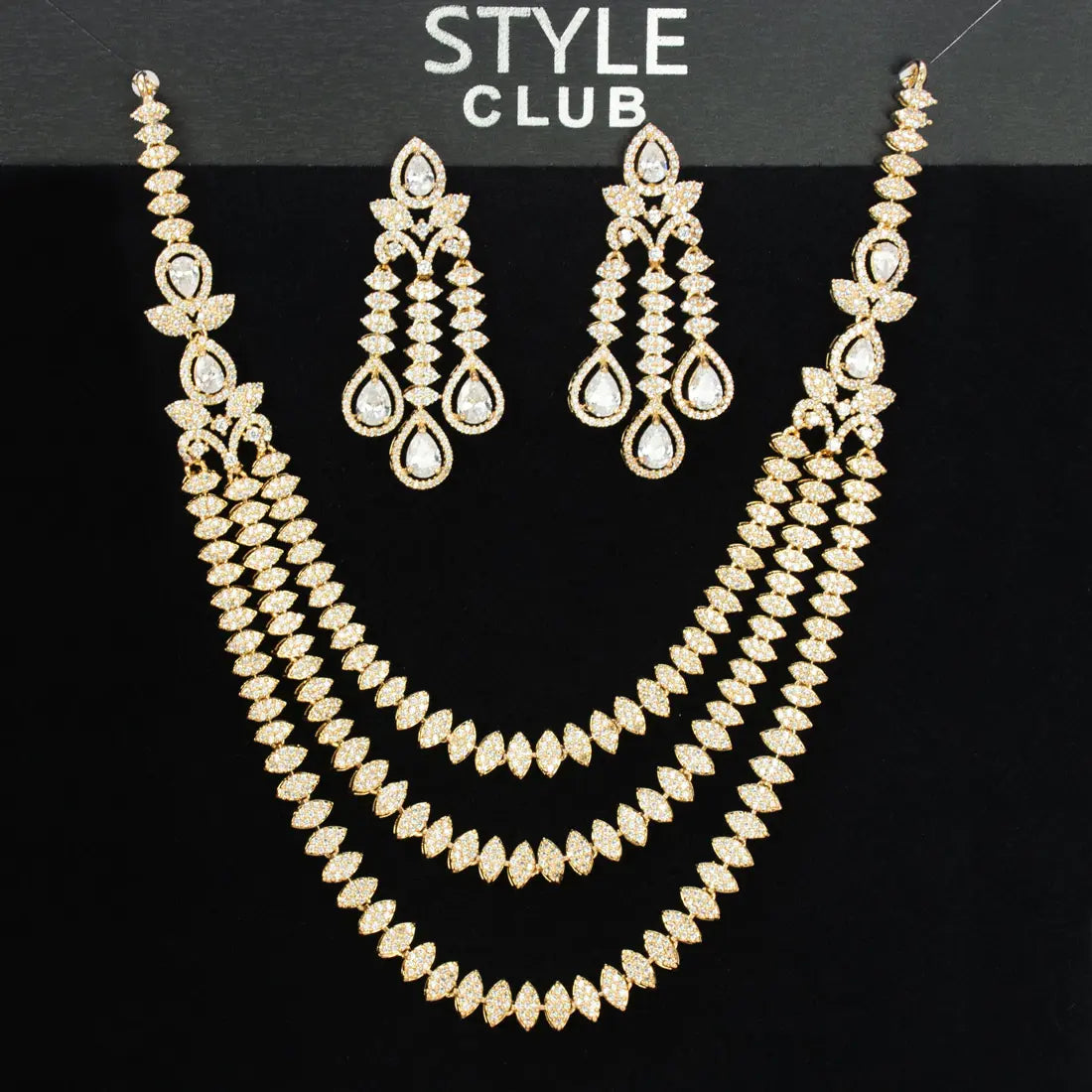 Gold necklace and earrings set on a black background with 'Style Club' branding.