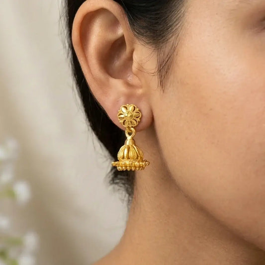 Gold Plated Simple Small Kids Jhumka Earrings worn by a model, showcasing a floral stud and curved gold dome design.