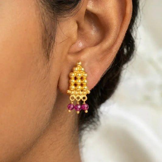 Gold Plated Crystal Hanging Beaded Studs showcasing pyramid-shaped gold beads and ruby-red crystal dangles.