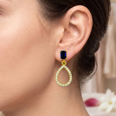 Sparkling Blue Sapphire Stone Studs CZ Drop Earrings worn on a model's ear showcasing elegance and glamour.