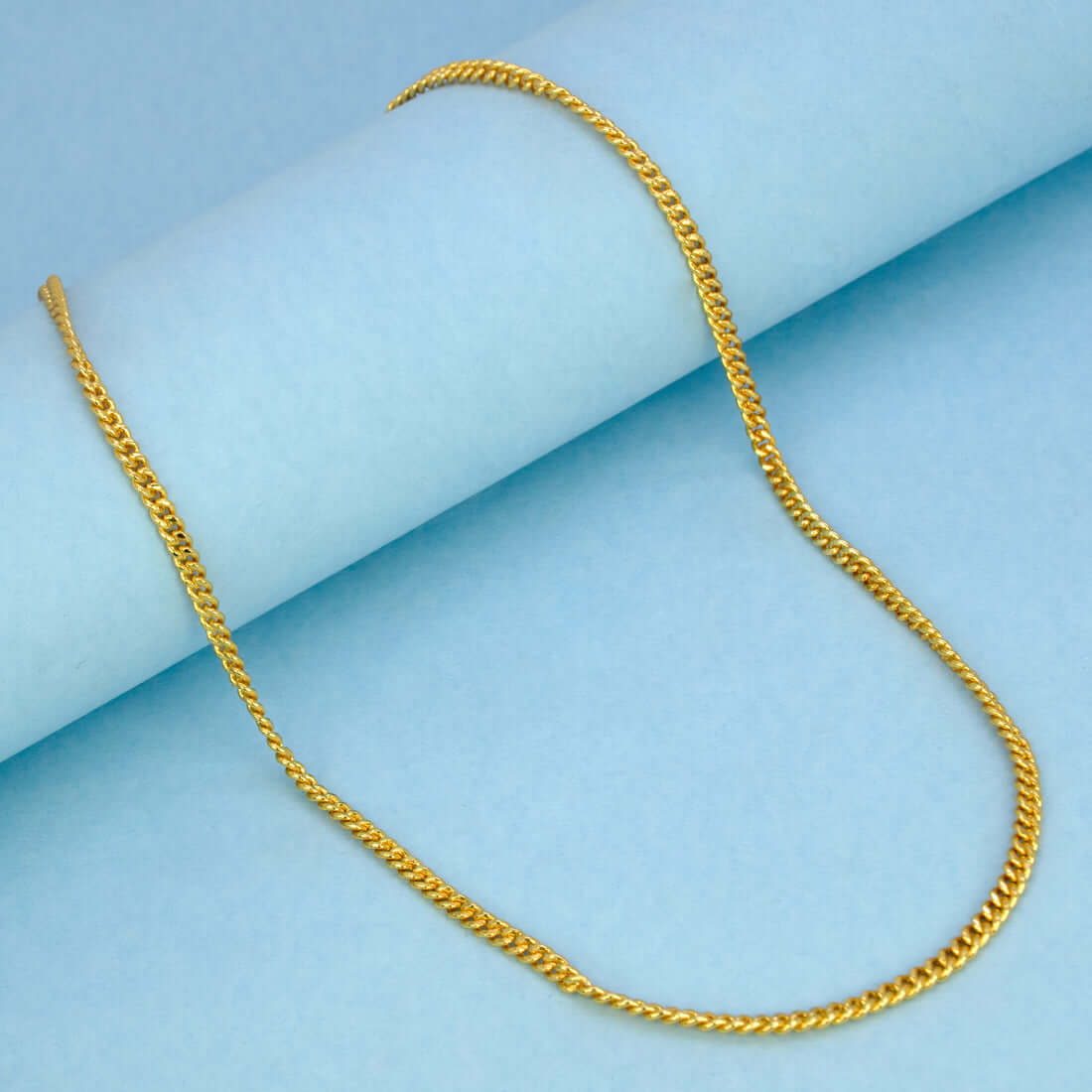 Stylish Gold Plated Unisex Thin Curb Link Chain displayed on a light blue background.