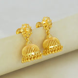Gold earrings with intricate designs on a light background