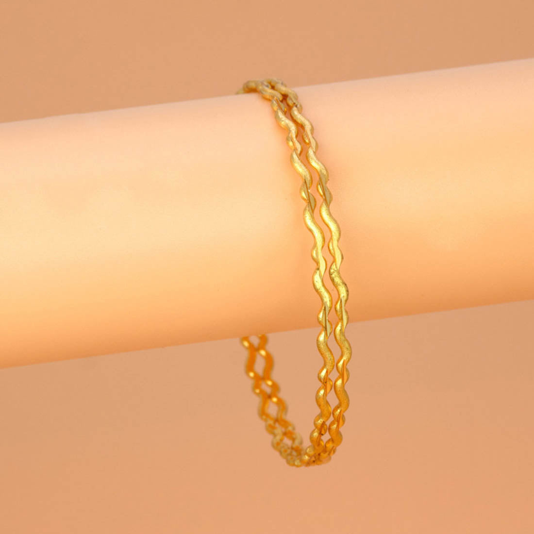 Delicate Gold Plated Wave Pattern Bangles displayed on a soft background, showcasing their elegant design and sheen.