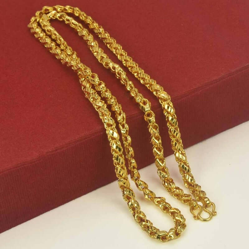 Gold Plated Nice Designer Saniya Chain resting on a red background, showcasing its stylish design and shiny finish.