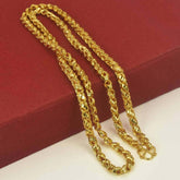Gold Plated Nice Designer Saniya Chain resting on a red background, showcasing its stylish design and shiny finish.