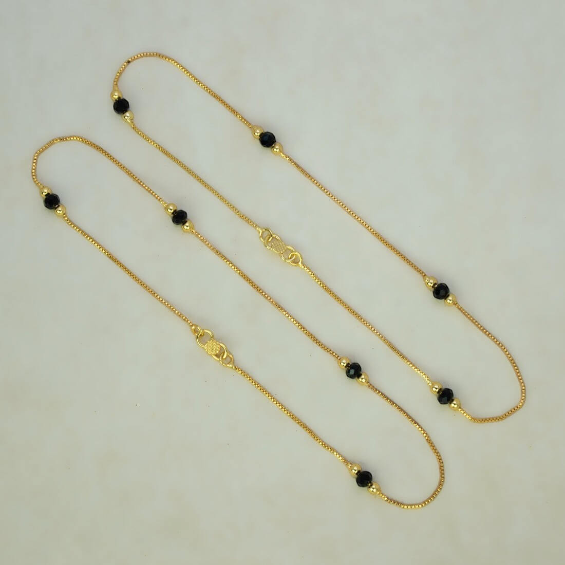 K Supreme gold plated brass anklets with box chain, black crystals, and gold beads. S hook closure.