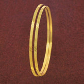 Thin Gold Plated Designer Daily Wear Bangles for Girls stacked elegantly on a textured background.
