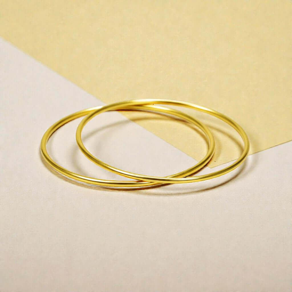 Gold Plated Thin Plain Bangles displayed on a minimalist background, showcasing their sleek design.