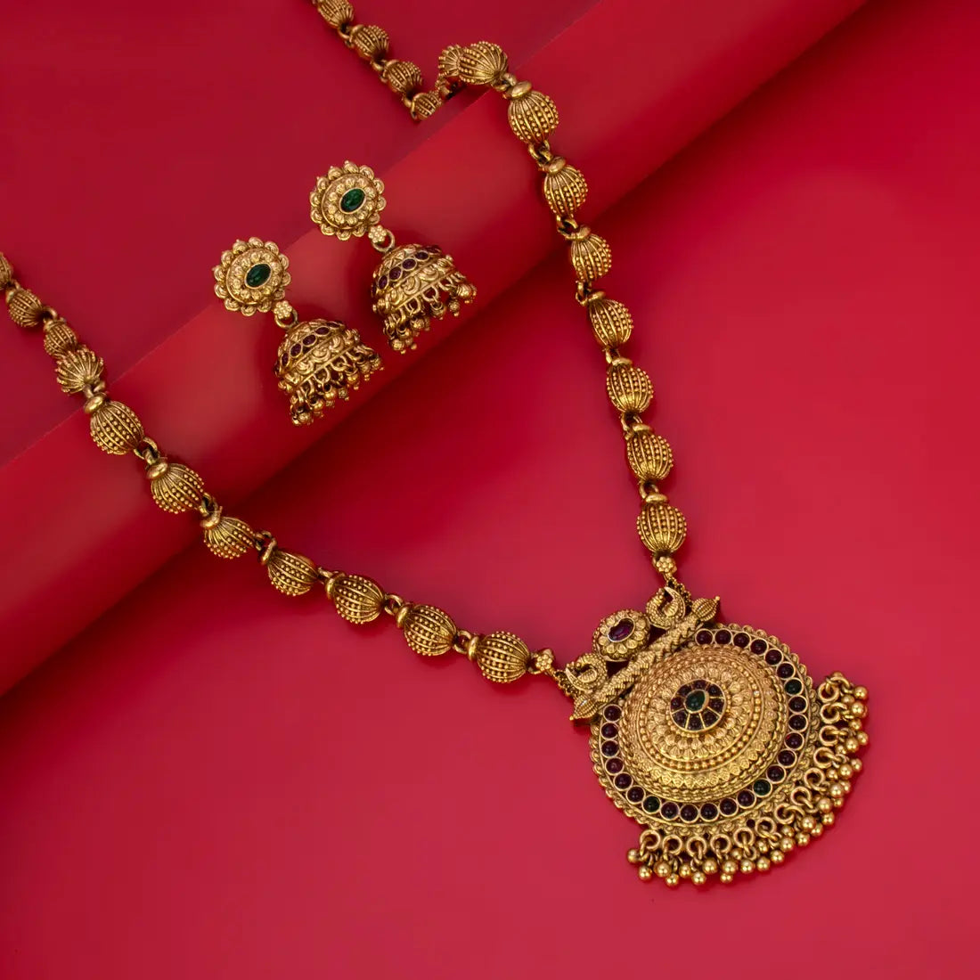 Antique Gold Beaded Multi-Colour Kemp Long Necklace Set with ornate earrings on a red background.
