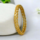 Plain Gold Plated Designer Bangle showcasing a twisted gold design on a marble surface.