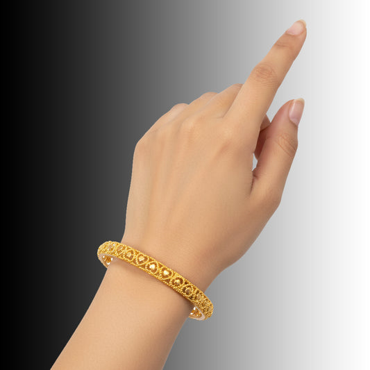 Elegant Gold Plated Heart Designer Medium Bangle worn on a hand, showcasing its delicate heart cutout pattern.