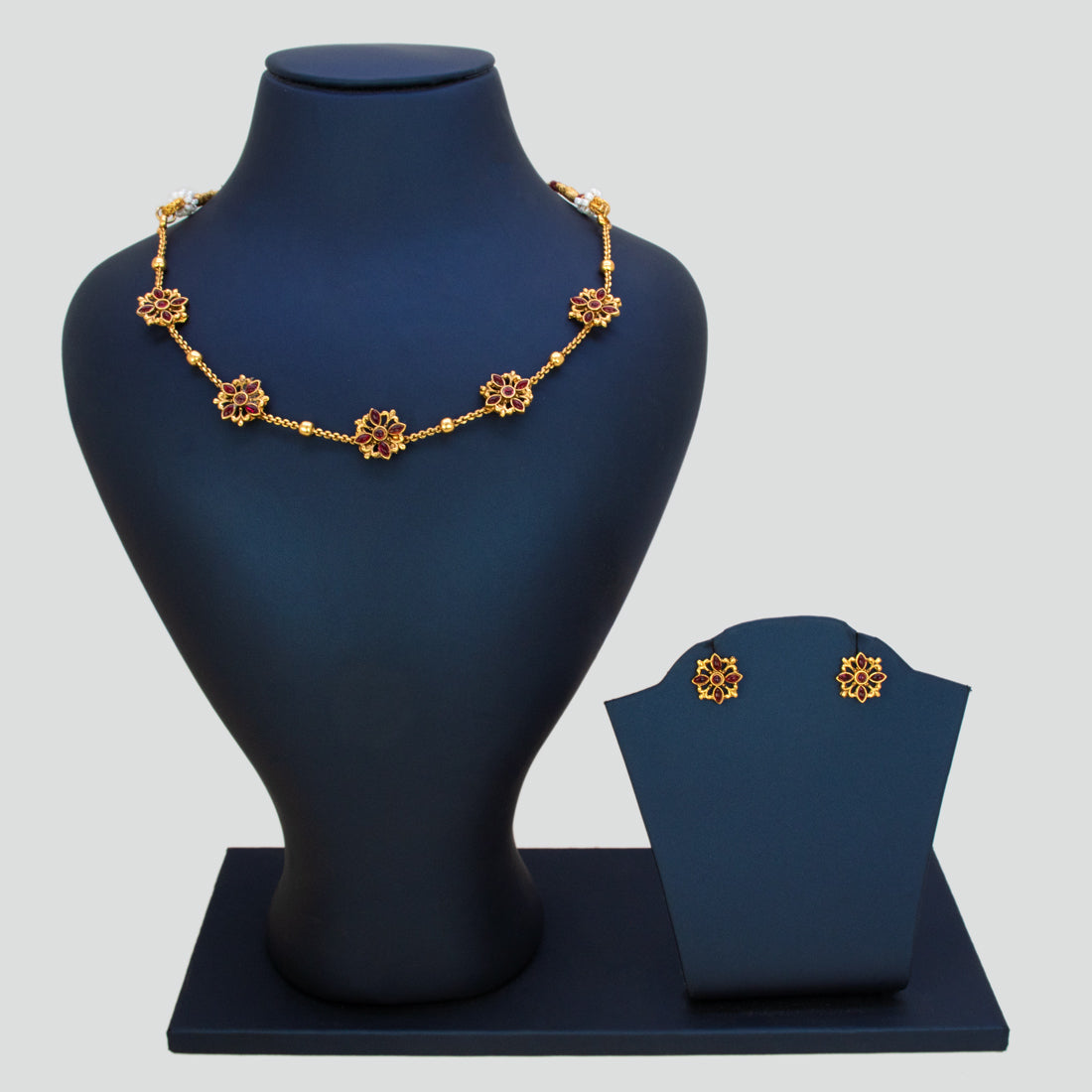 Floral Kemp Stone Antique Gold Choker Necklace Set displayed on a jewelry stand with matching earrings.