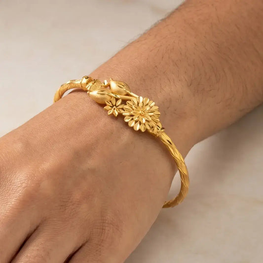 Gold Plated Floral Bouquet Bangle worn on wrist showcasing floral design and radiant yellow gold.