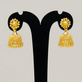 Pair of gold earrings on a black stand against a light gray background