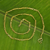 One Gram Gold Trendy Thin Figaro Unisex Sachin Chain showcased on a green leaf background.